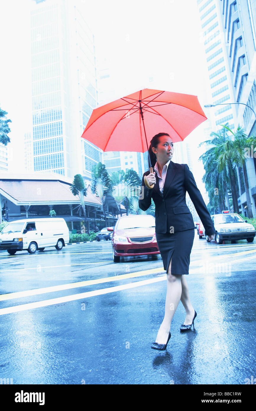 Business woman with umbrella, crossing the road Stock Photo - Alamy