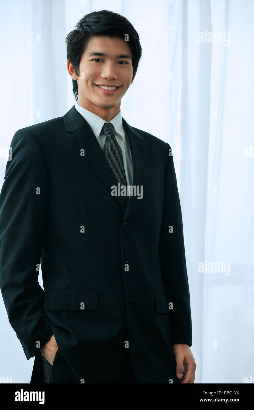 A groom wearing a suit smiles at the camera Stock Photo - Alamy