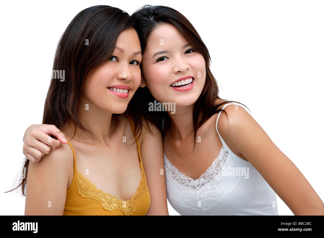 Two young women, arms around each other, smiling Stock Photo - Alamy