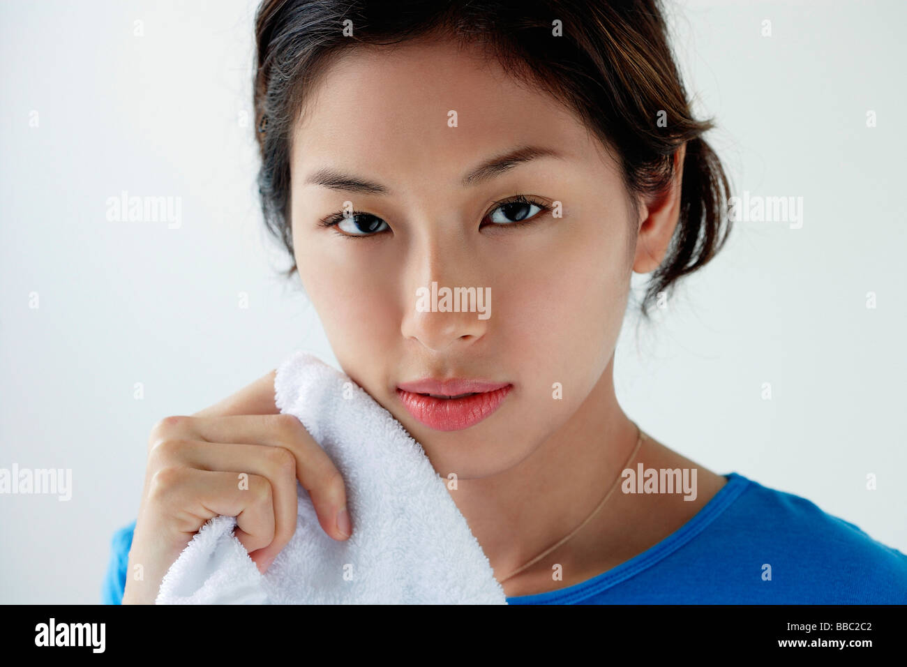 A young woman looks at the camera as she washes her face Stock Photo