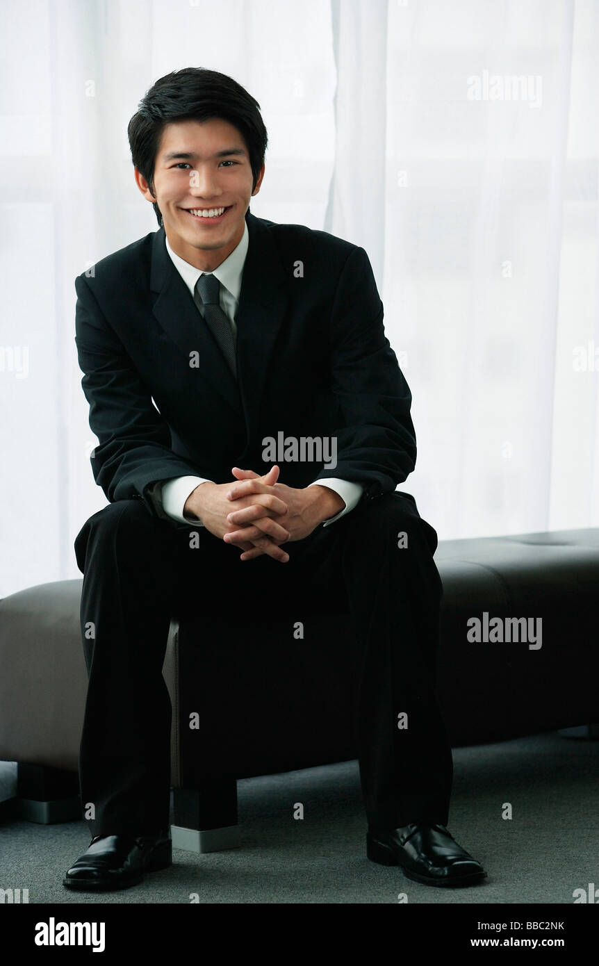 A groom wearing a suit smiles at the camera Stock Photo - Alamy