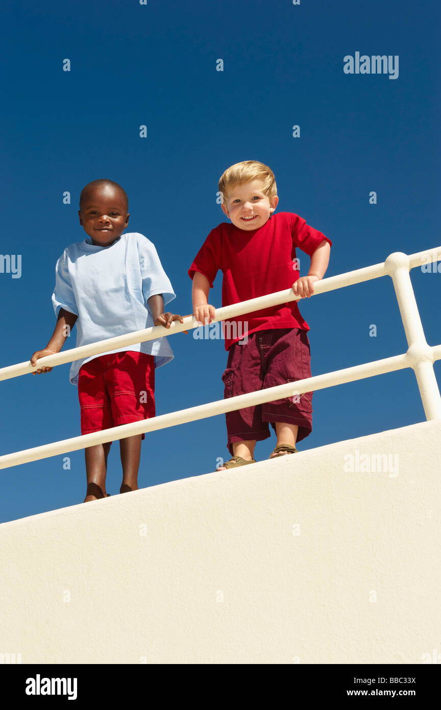 Young boys leaning over railing Stock Photo