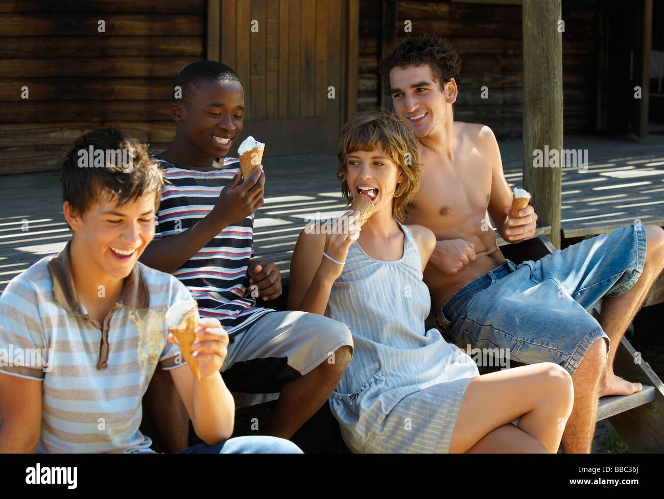 Teenagers eating ice cream on veranda Stock Photo