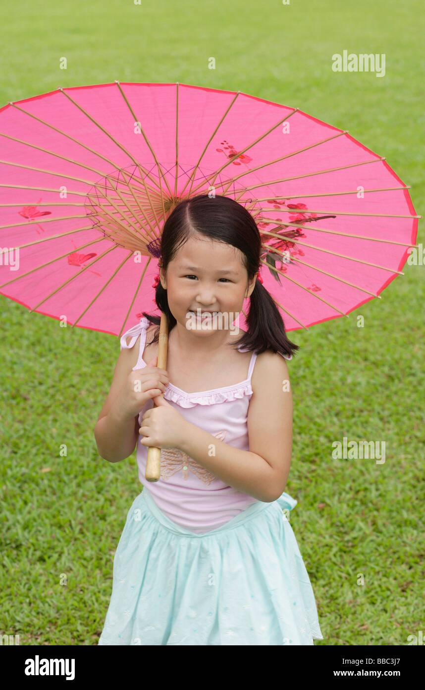 Girl using pink traditional Chinese paper umbrella Stock Photo - Alamy