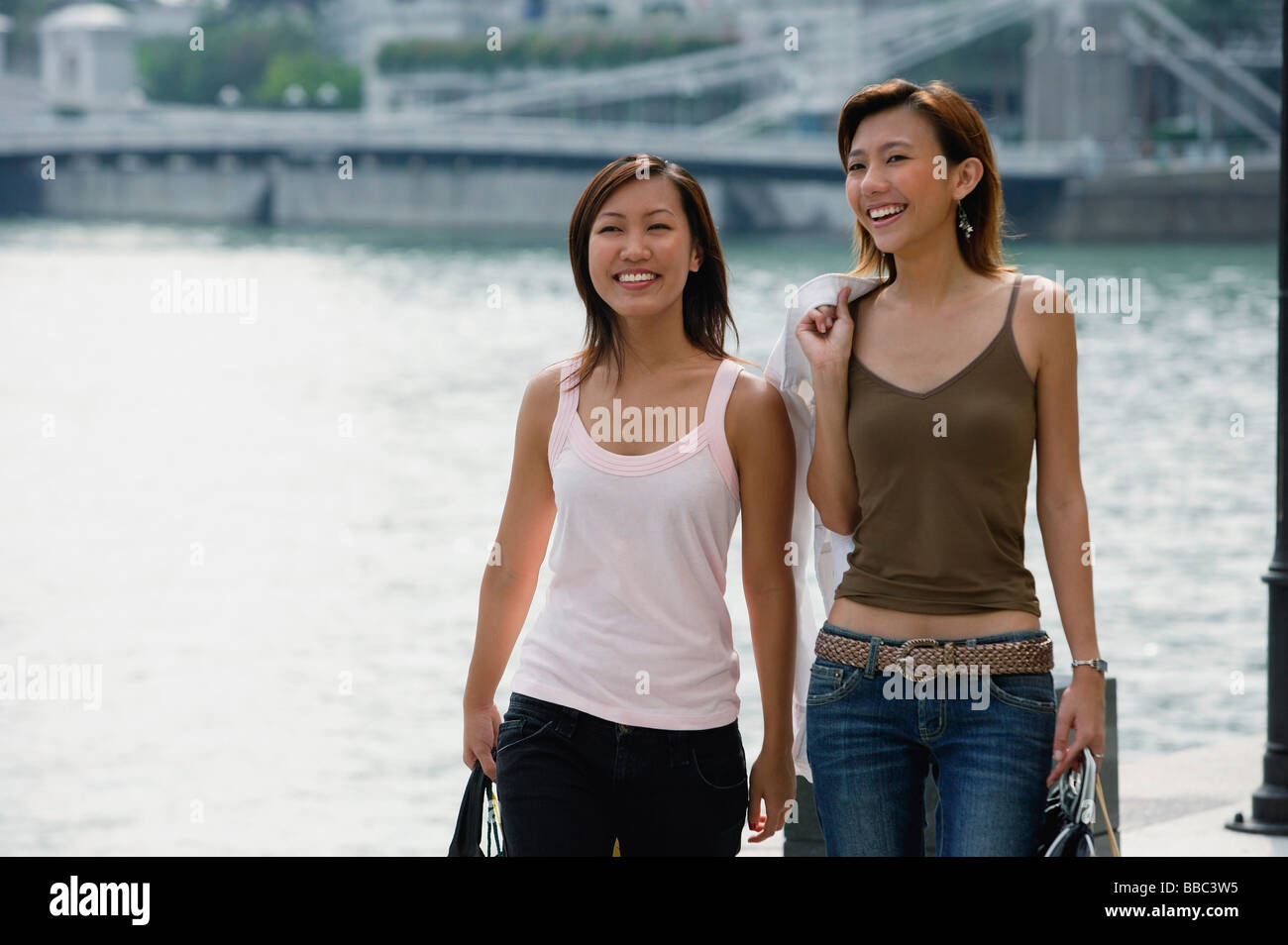 Two women walking side by side Stock Photo - Alamy