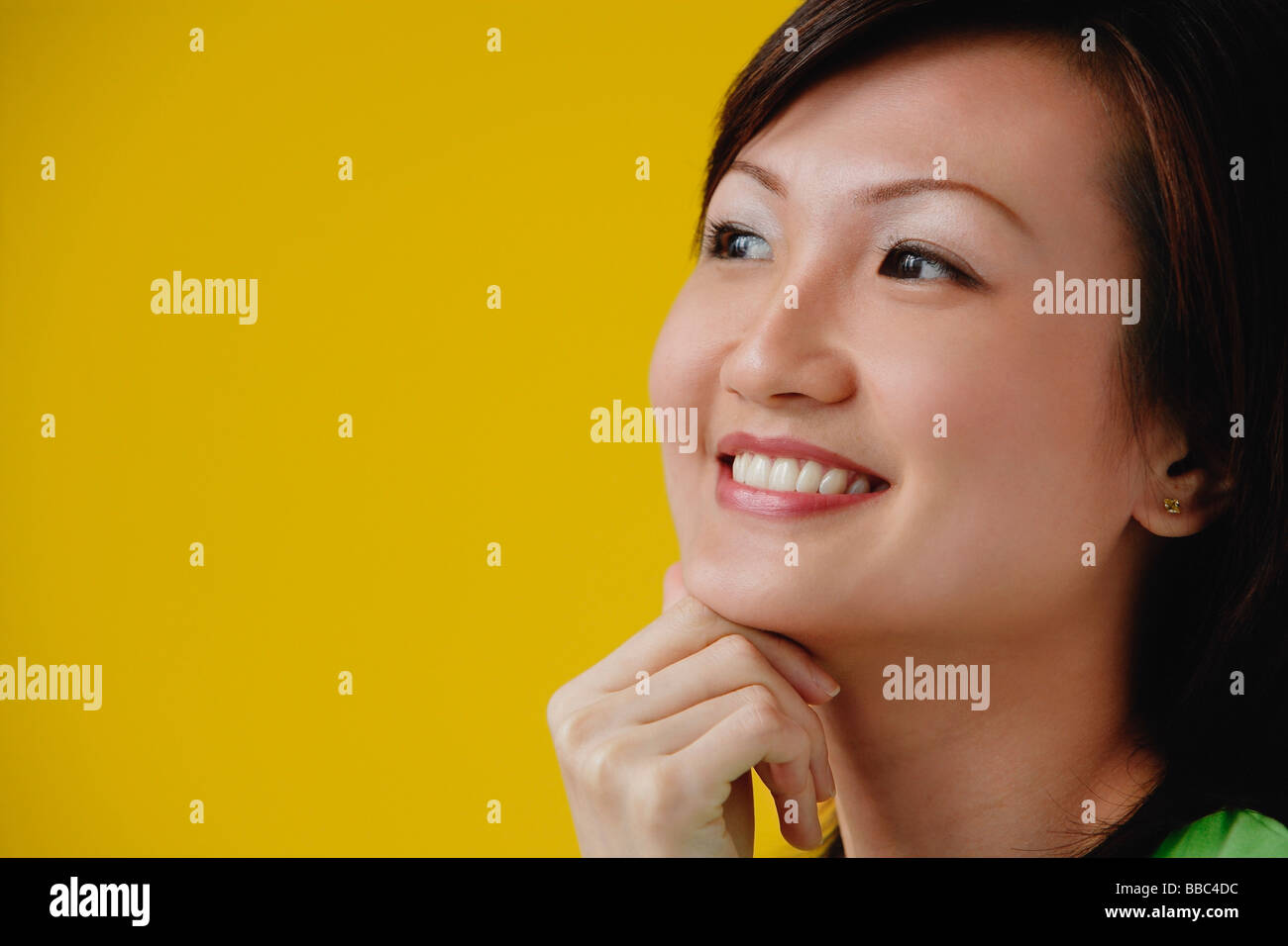 Young Woman with hand on chin, smiling Stock Photo - Alamy