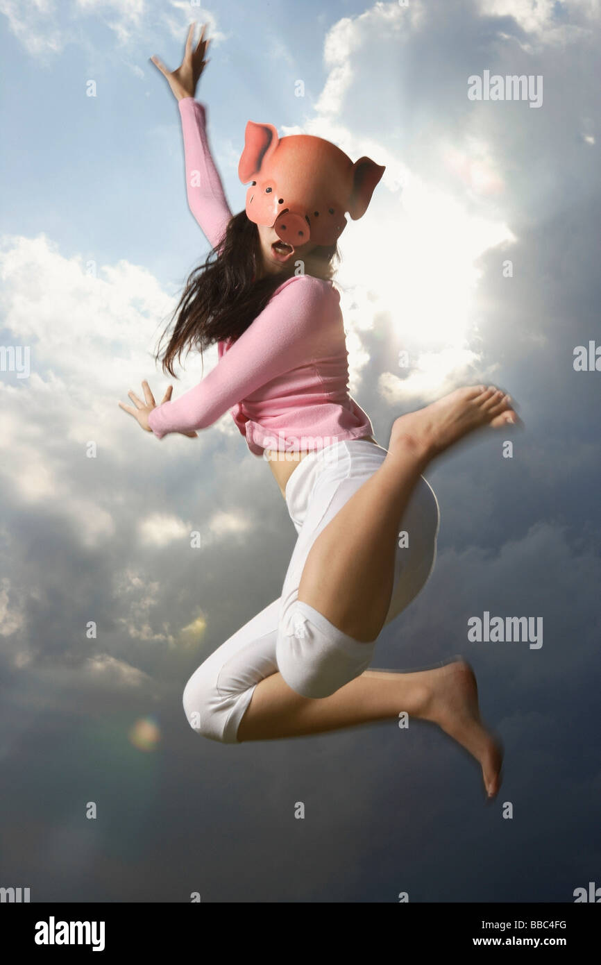 young lady with pig mask, jumping high Stock Photo