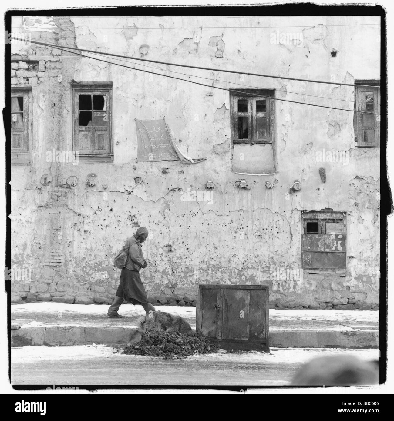 India, Ladakh, Leh, man walking past building. Stock Photo