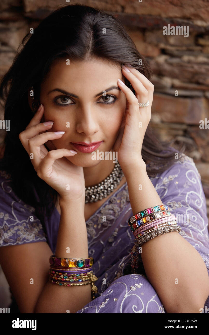 young woman in sari, hands on face Stock Photo