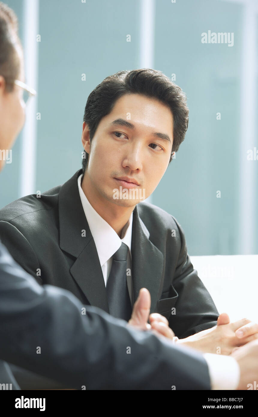 Businessmen sitting side by side Stock Photo - Alamy