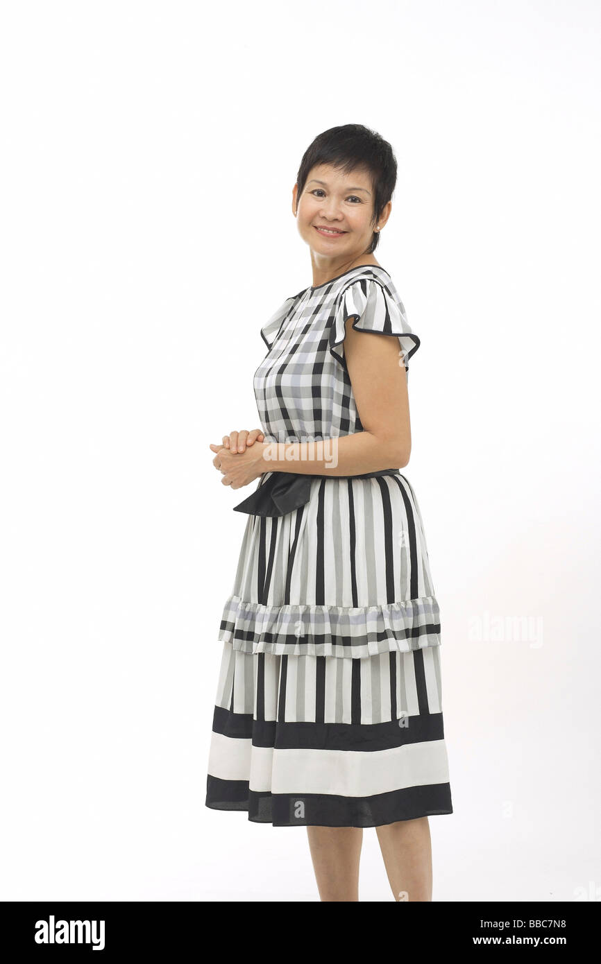 Mature woman against white background, smiling at camera Stock Photo ...