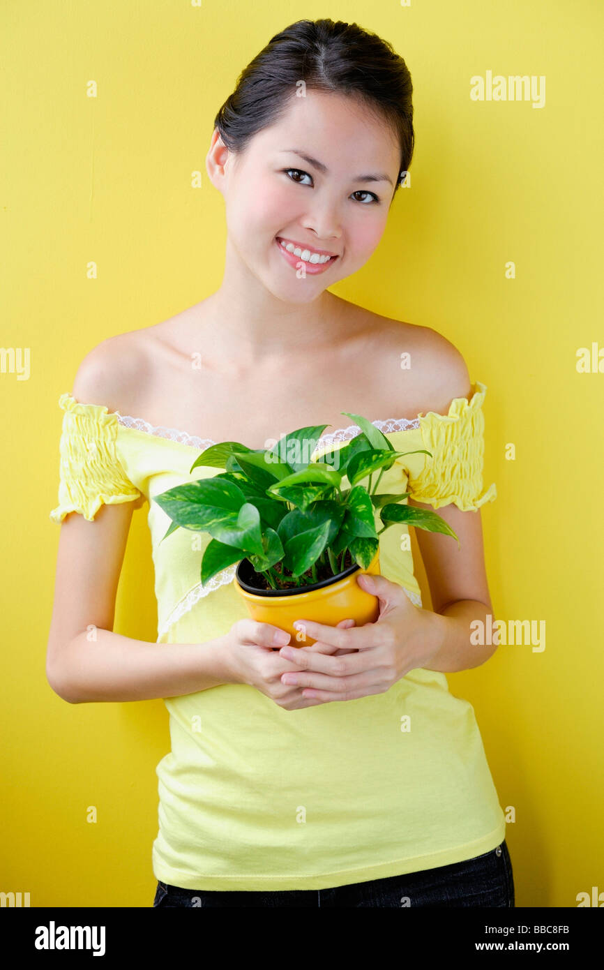 Woman holding house plant Stock Photo