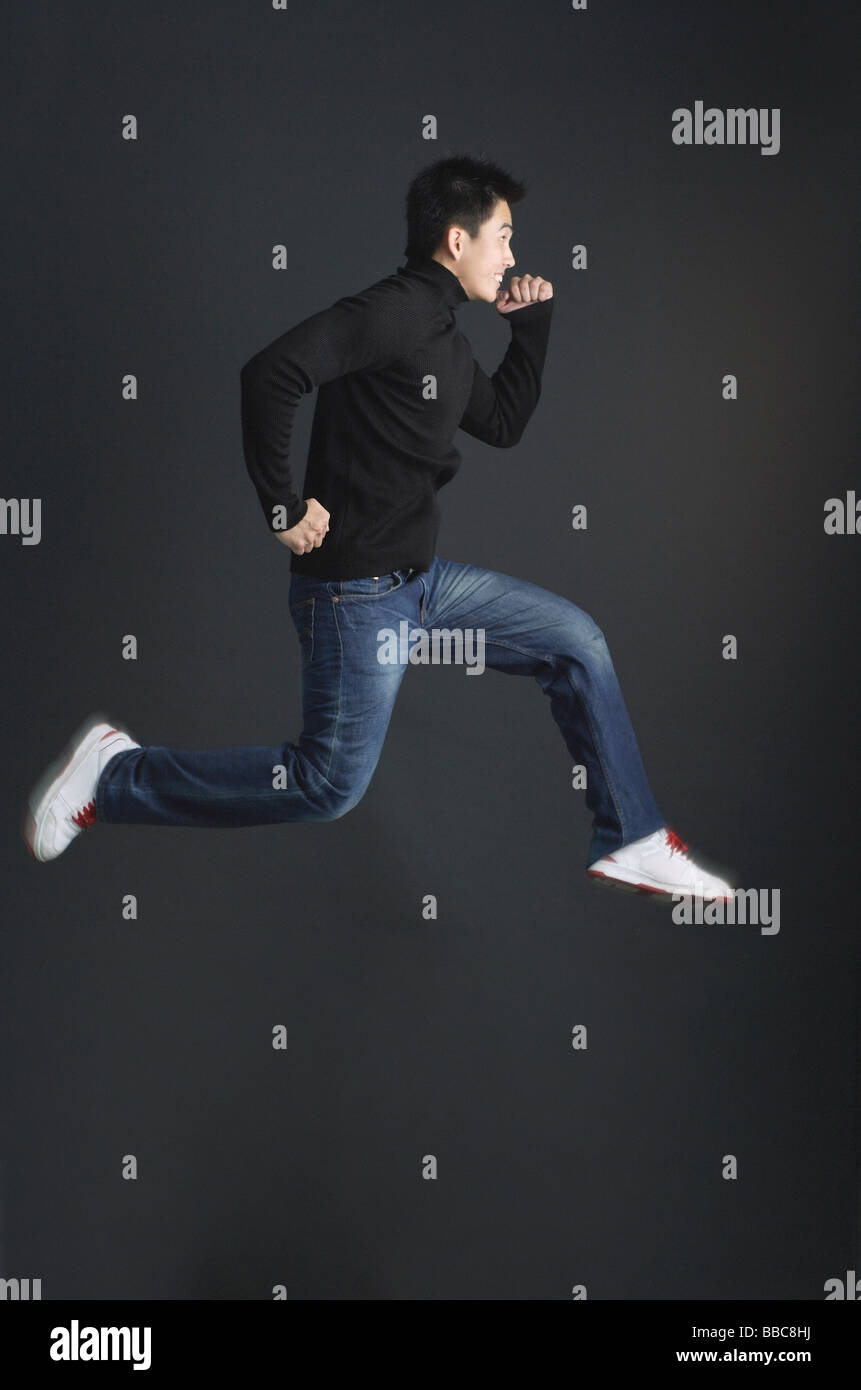 Young man dressed in black jumping in air Stock Photo - Alamy