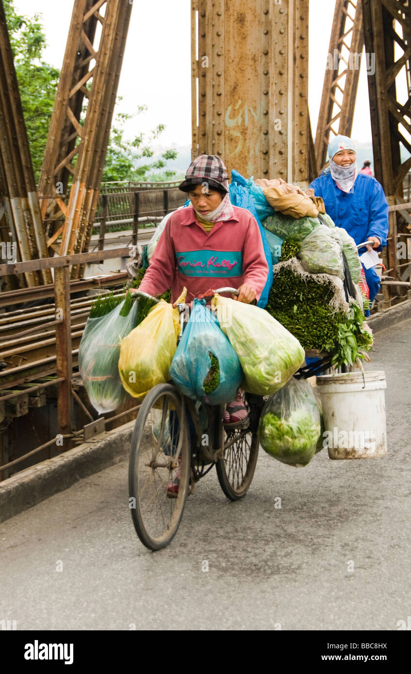 Vietnamese folks riding bicycle on Long bien bridge over the red river, Hanoi, vietnam. Stock Photo