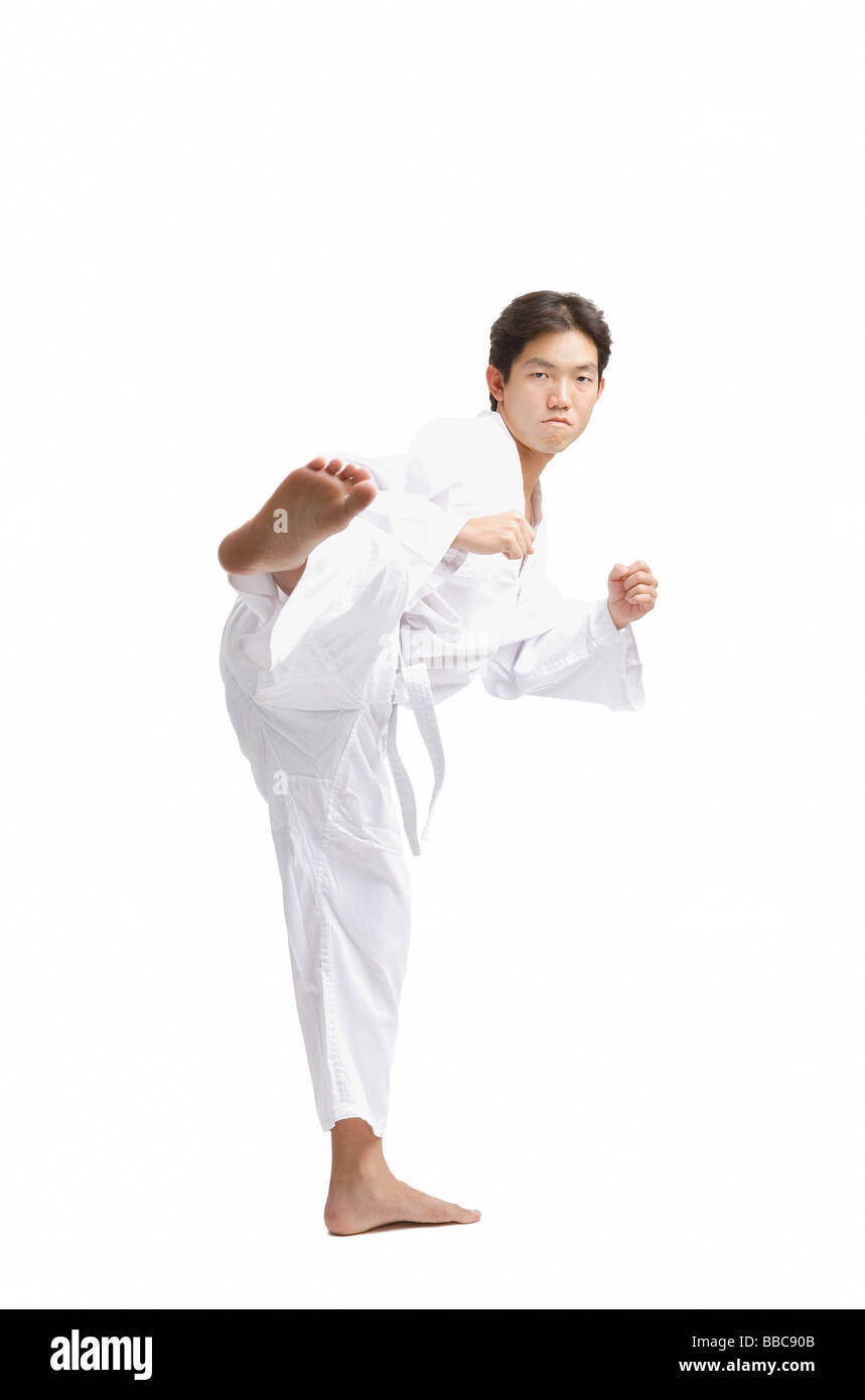 Young man practicing martial arts, kicking Stock Photo Alamy