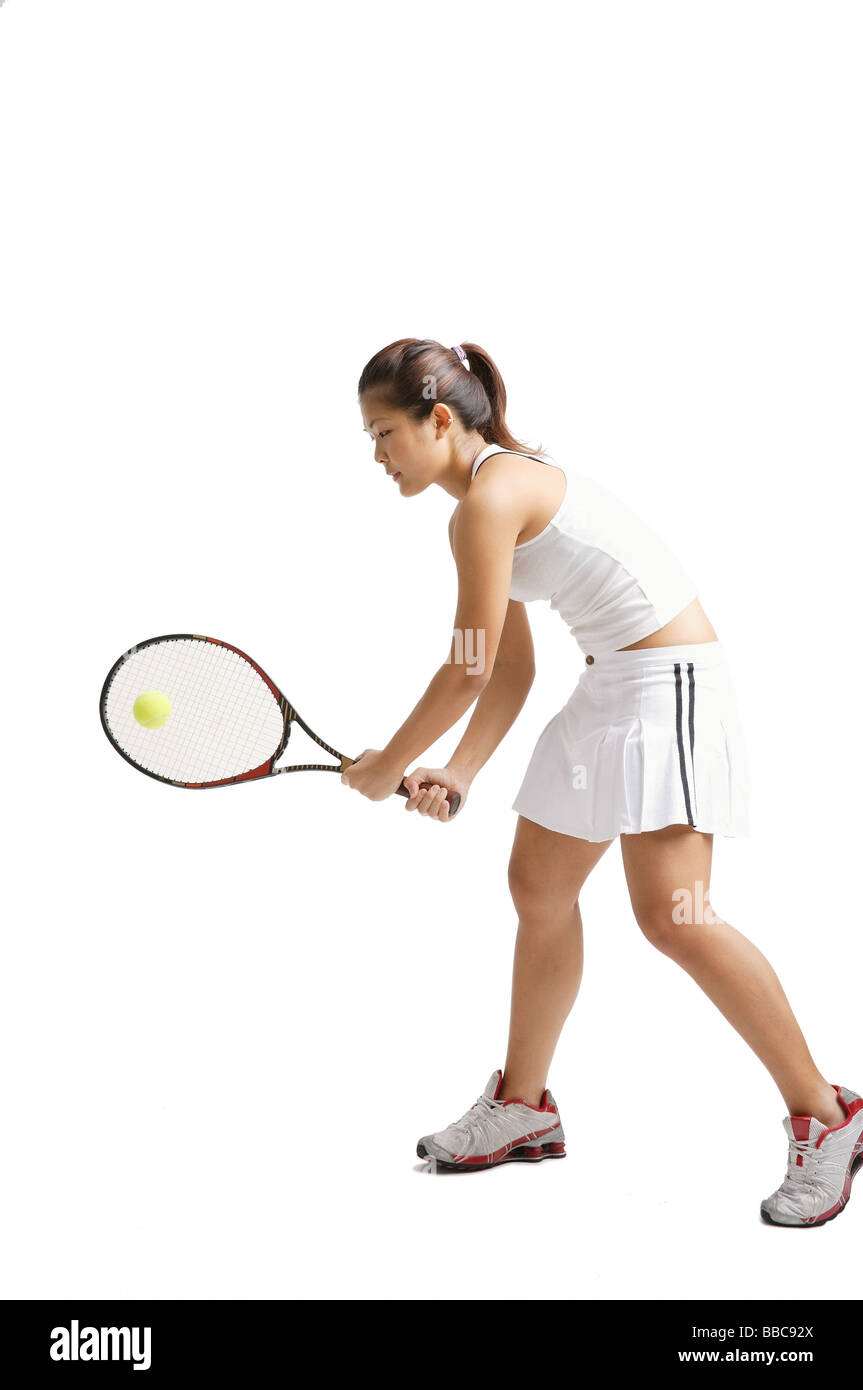 Young woman playing tennis, studio shot Stock Photo