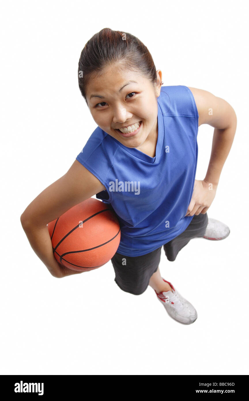 Young woman holding basketball, smiling at camera Stock Photo - Alamy