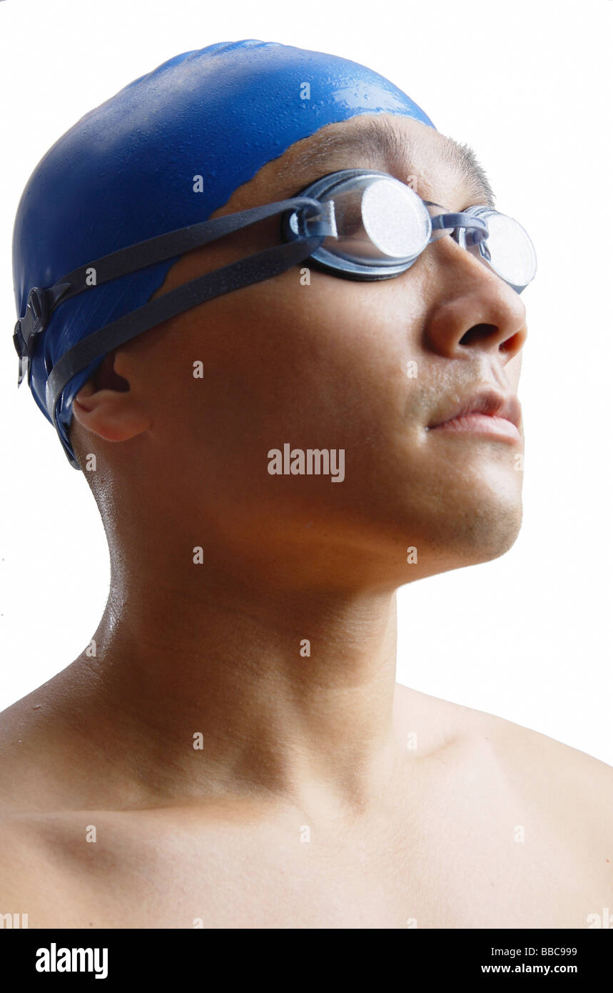 Young man wearing swimming cap and goggles, head shot Stock Photo