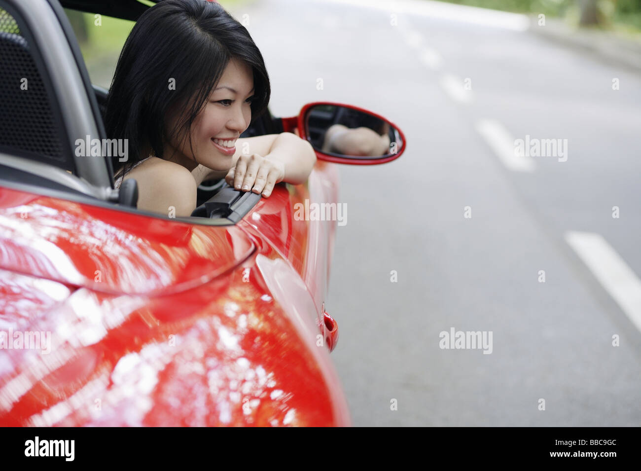 Woman sitting in red sports car Stock Photo - Alamy