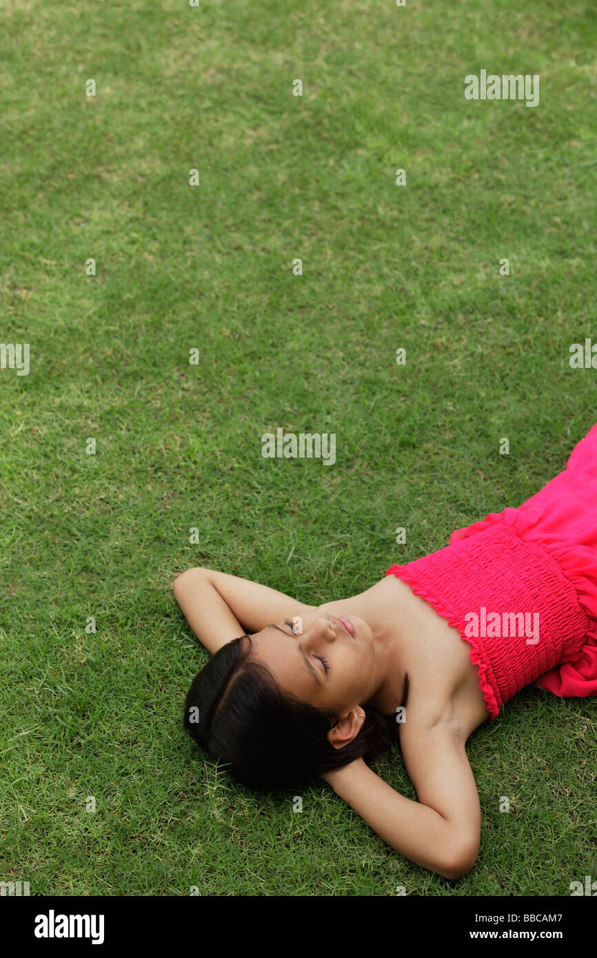 little girl in pink dress sleeping in park Stock Photo