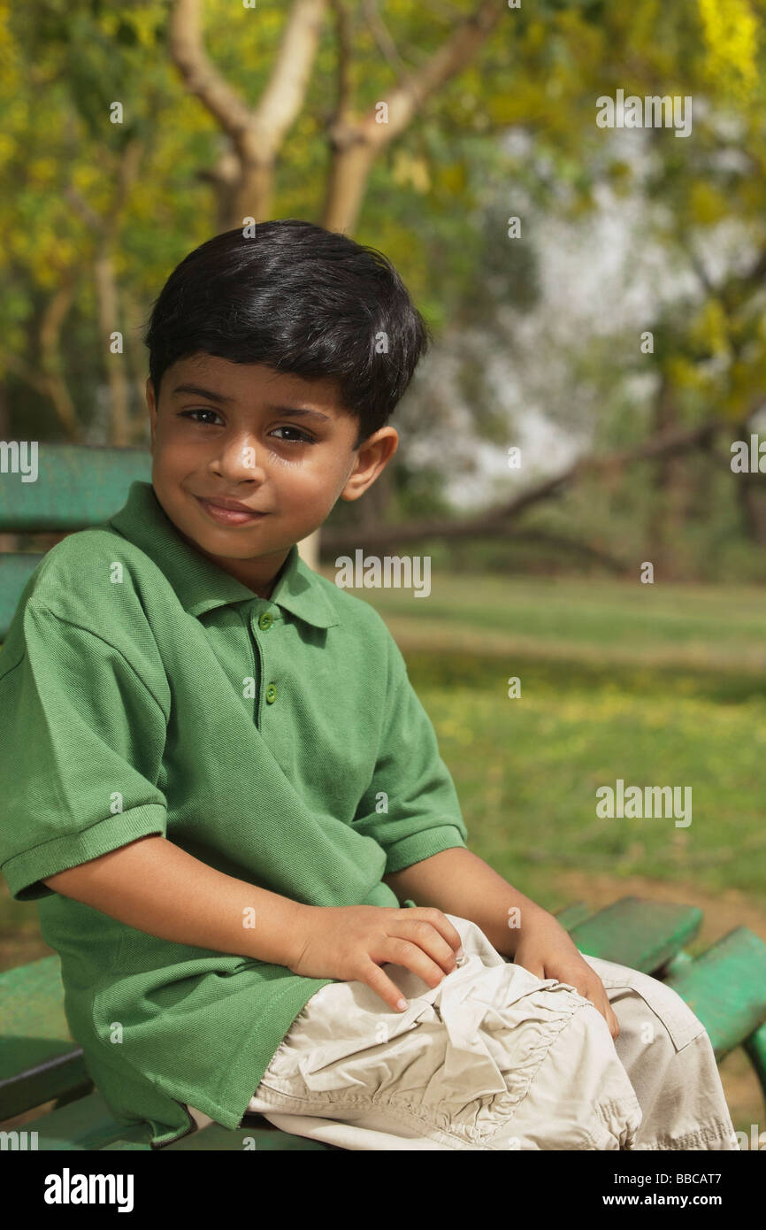 Little boy sitting on park bench Stock Photo - Alamy