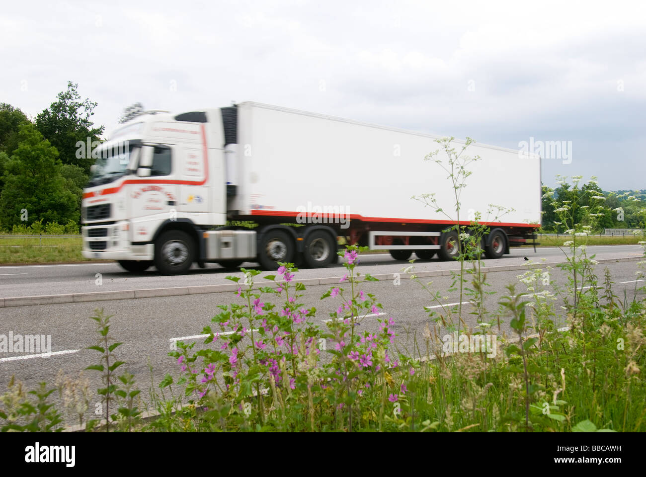 Side view of a white articulated lorry speeding along an English road Stock Photo