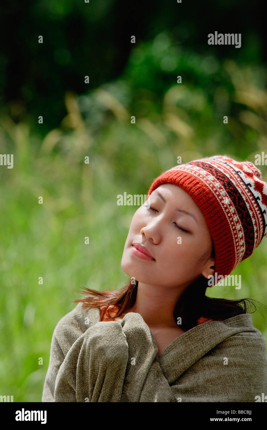 Woman with ski cap, wrapped in a blanket, eyes closed Stock Photo Alamy