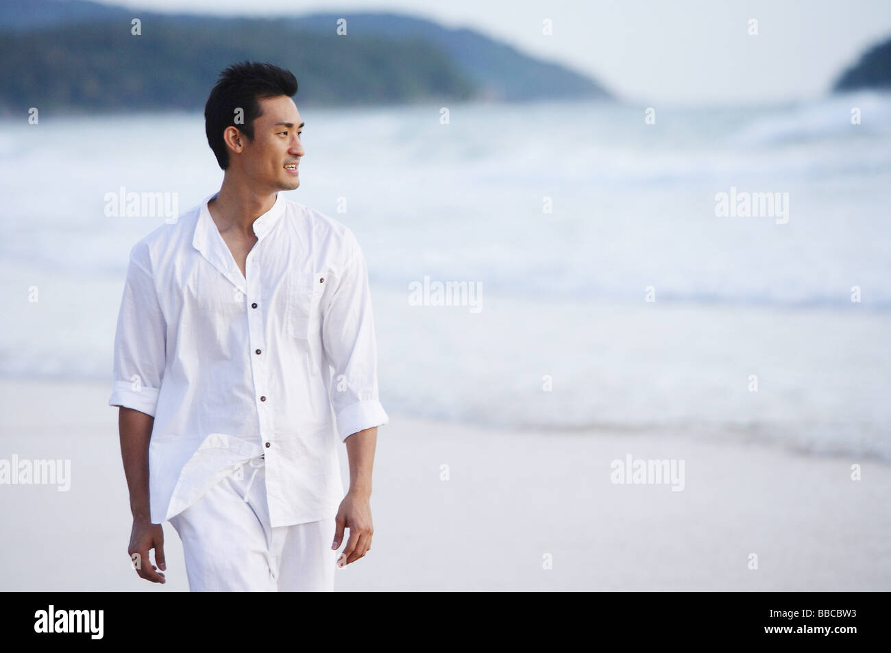 Man walking on beach Stock Photo - Alamy