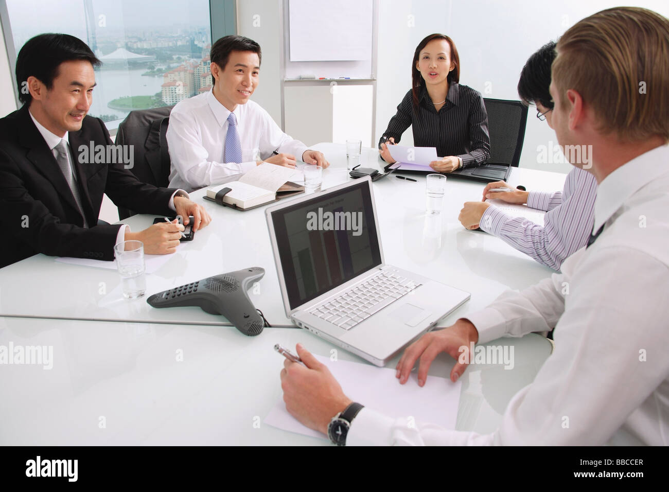Executives sitting around conference table, having a meeting Stock