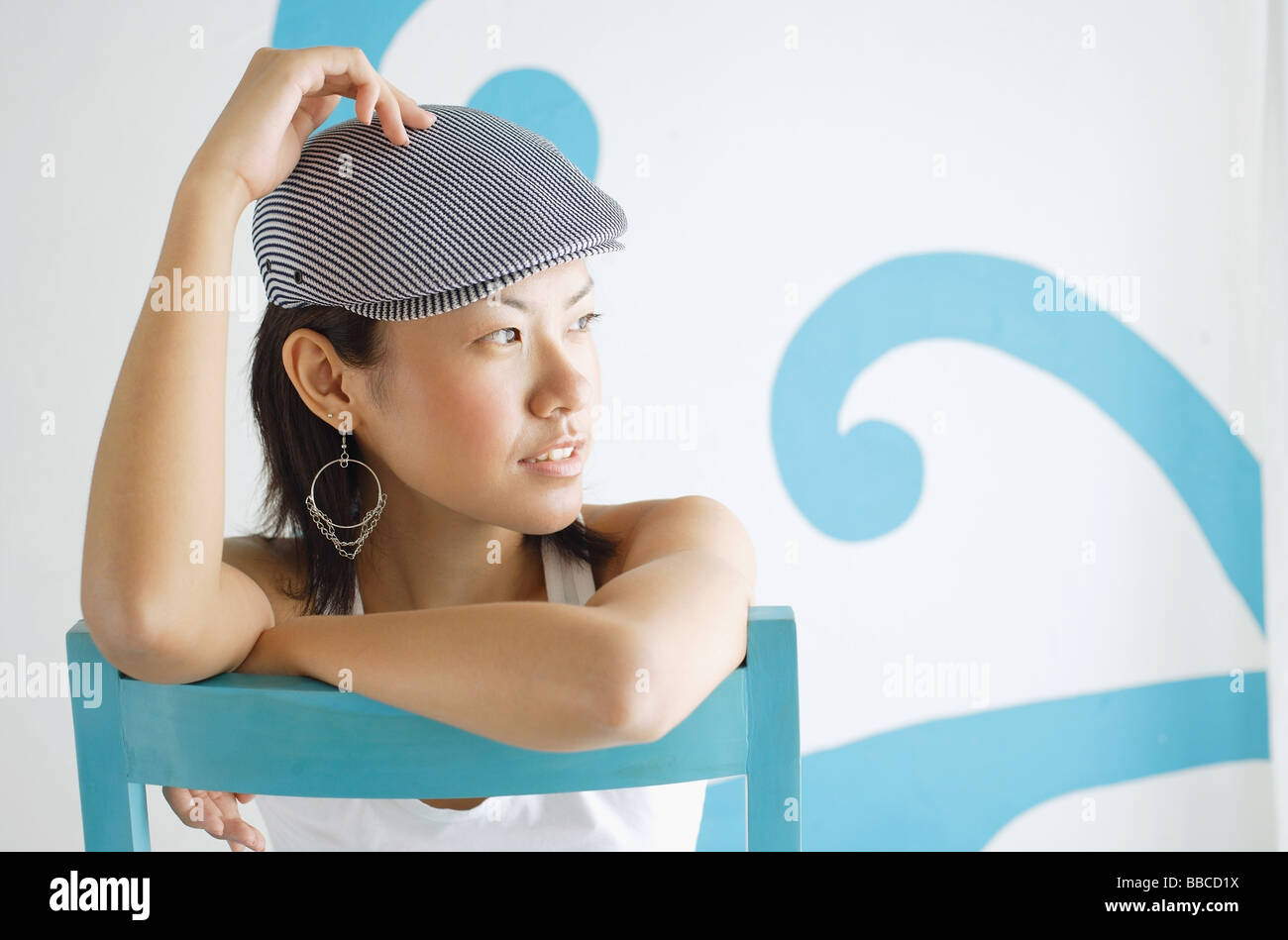 Young woman wearing beret, looking away, hand on head Stock Photo - Alamy