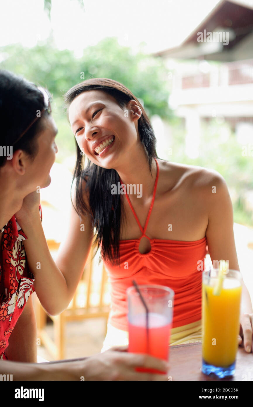 Couple sitting face to face, woman touching mans face Stock Photo