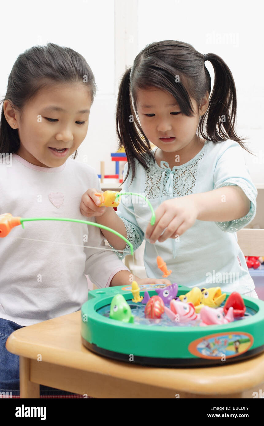 Two girls playing with fishing game Stock Photo Alamy