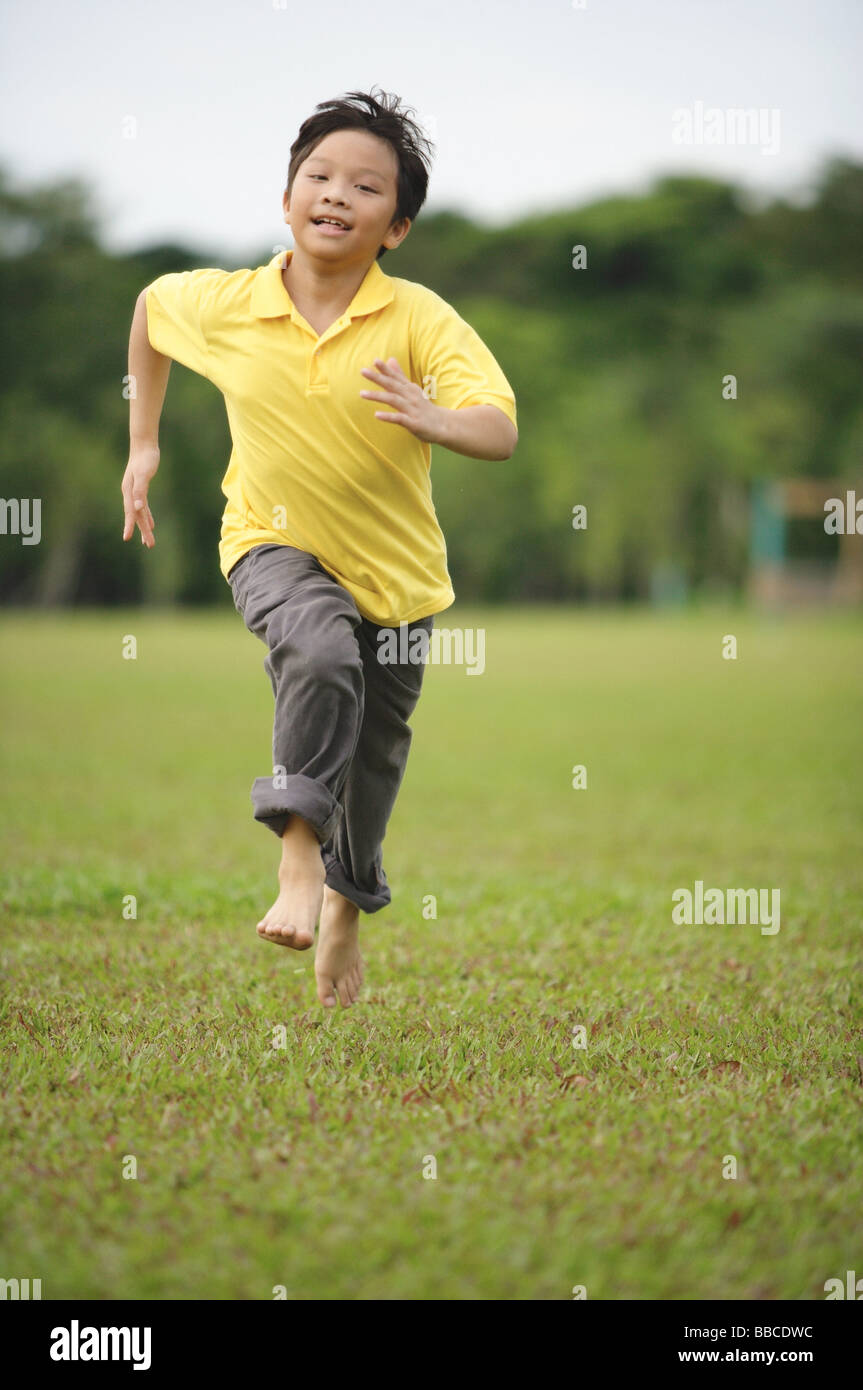 Boy running on grass Stock Photo - Alamy