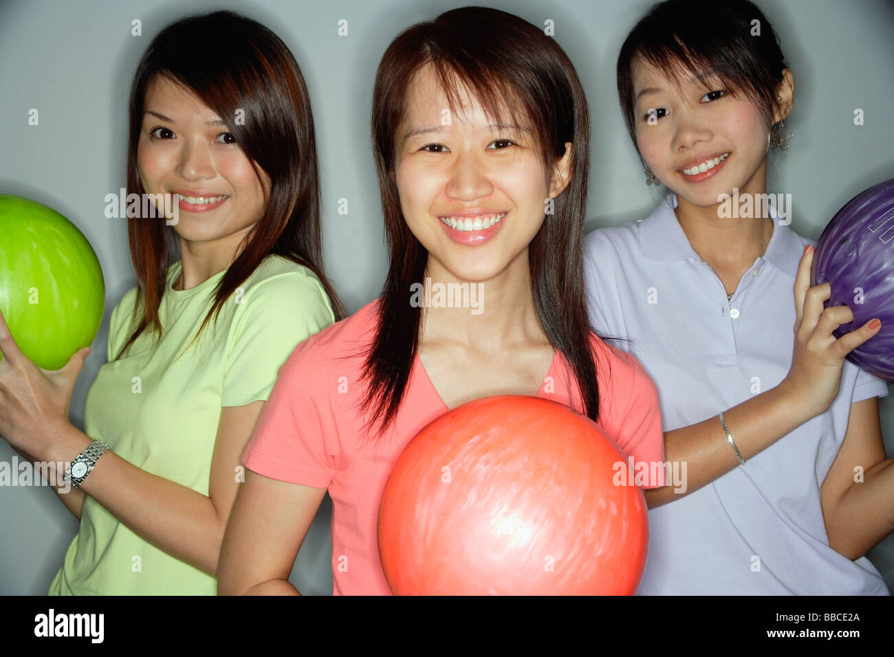 Three young women holding bowling balls hires stock photography and