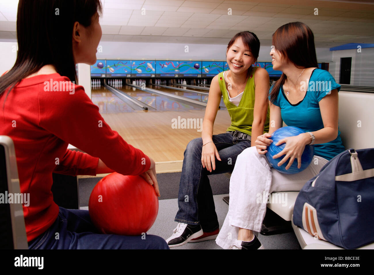 Women sitting in bowling alley Stock Photo Alamy