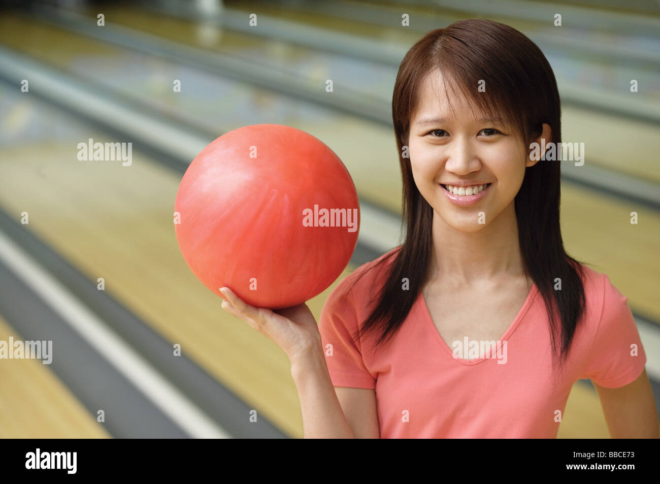 Woman at bowling alley with red bowling ball Stock Photo Alamy