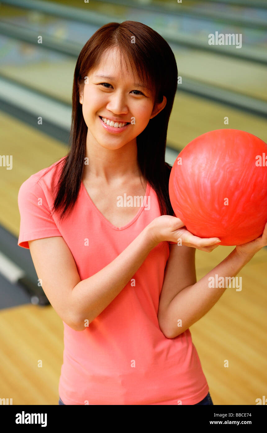Woman at bowling alley with red bowling ball Stock Photo Alamy
