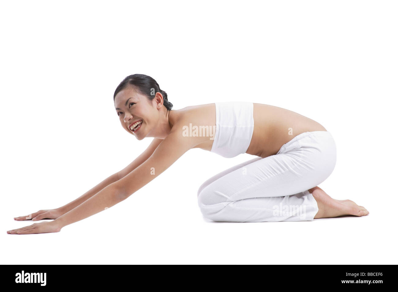 Woman kneeling on floor stretching Stock Photo - Alamy