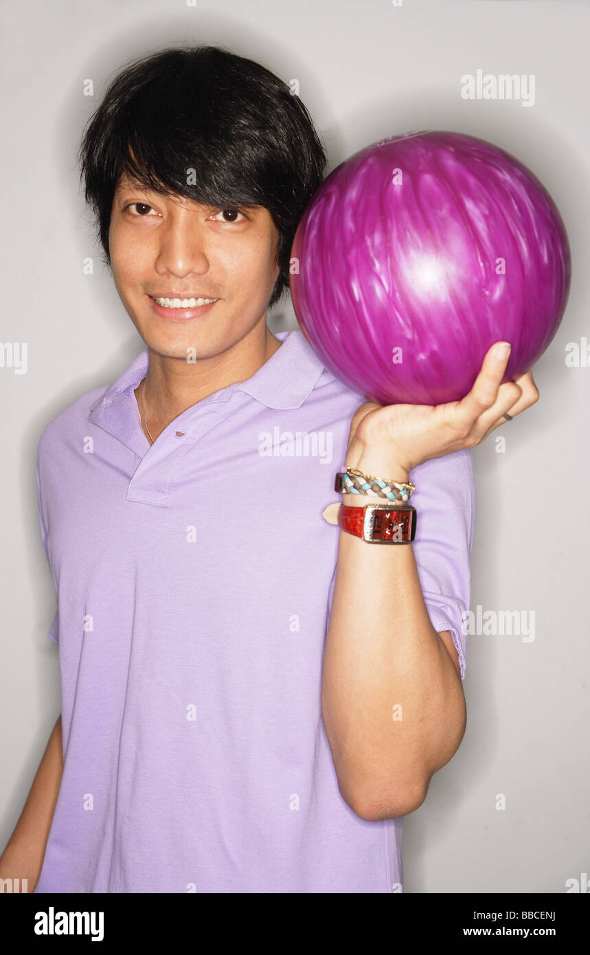 Man carrying bowling ball, smiling at camera Stock Photo Alamy