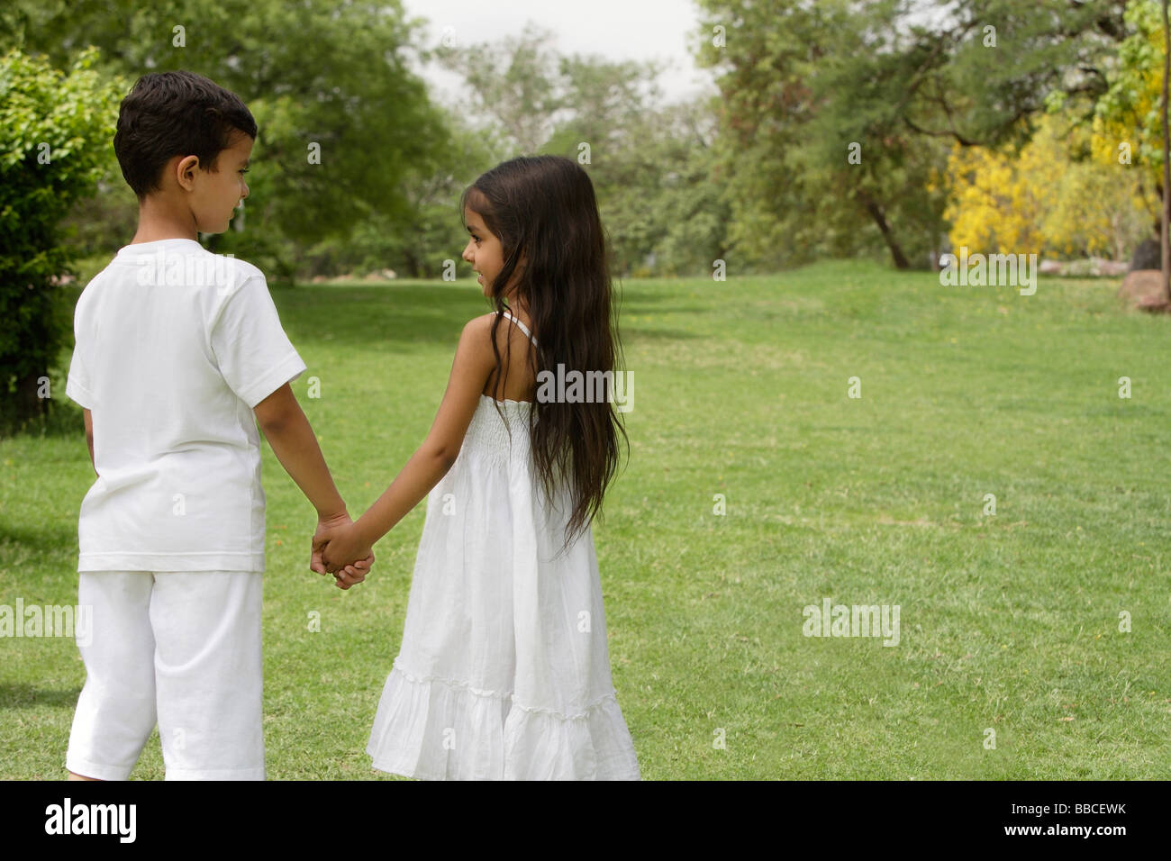 boy and girl holding hands in park Stock Photo - Alamy