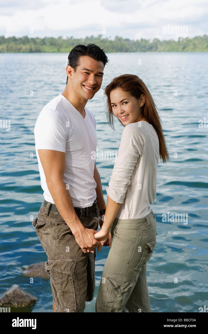 Couple standing hand in hand near lake Stock Photo Alamy