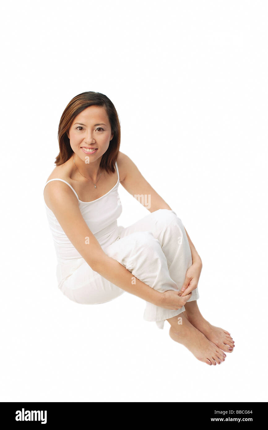 Woman sitting, hugging knees, looking up at camera Stock Photo - Alamy
