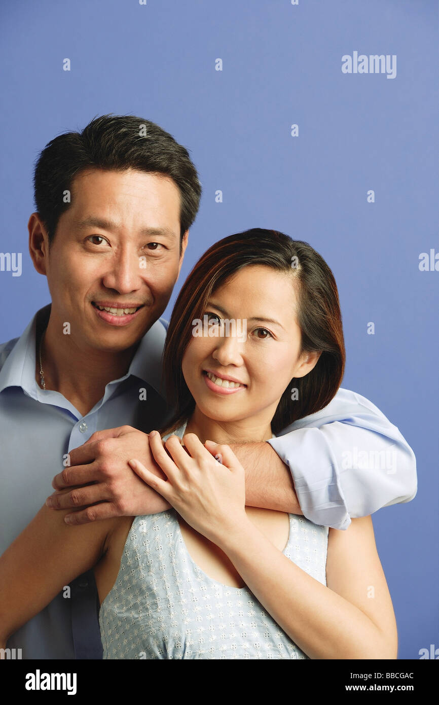 Man hugging woman, both facing camera, portrait Stock Photo - Alamy