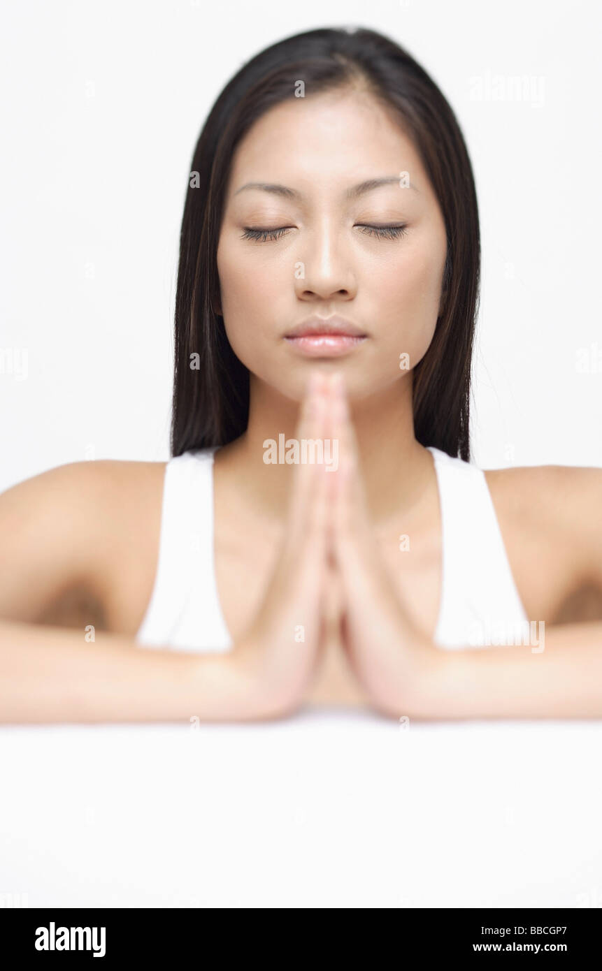 Woman eyes closed, hands together Stock Photo Alamy