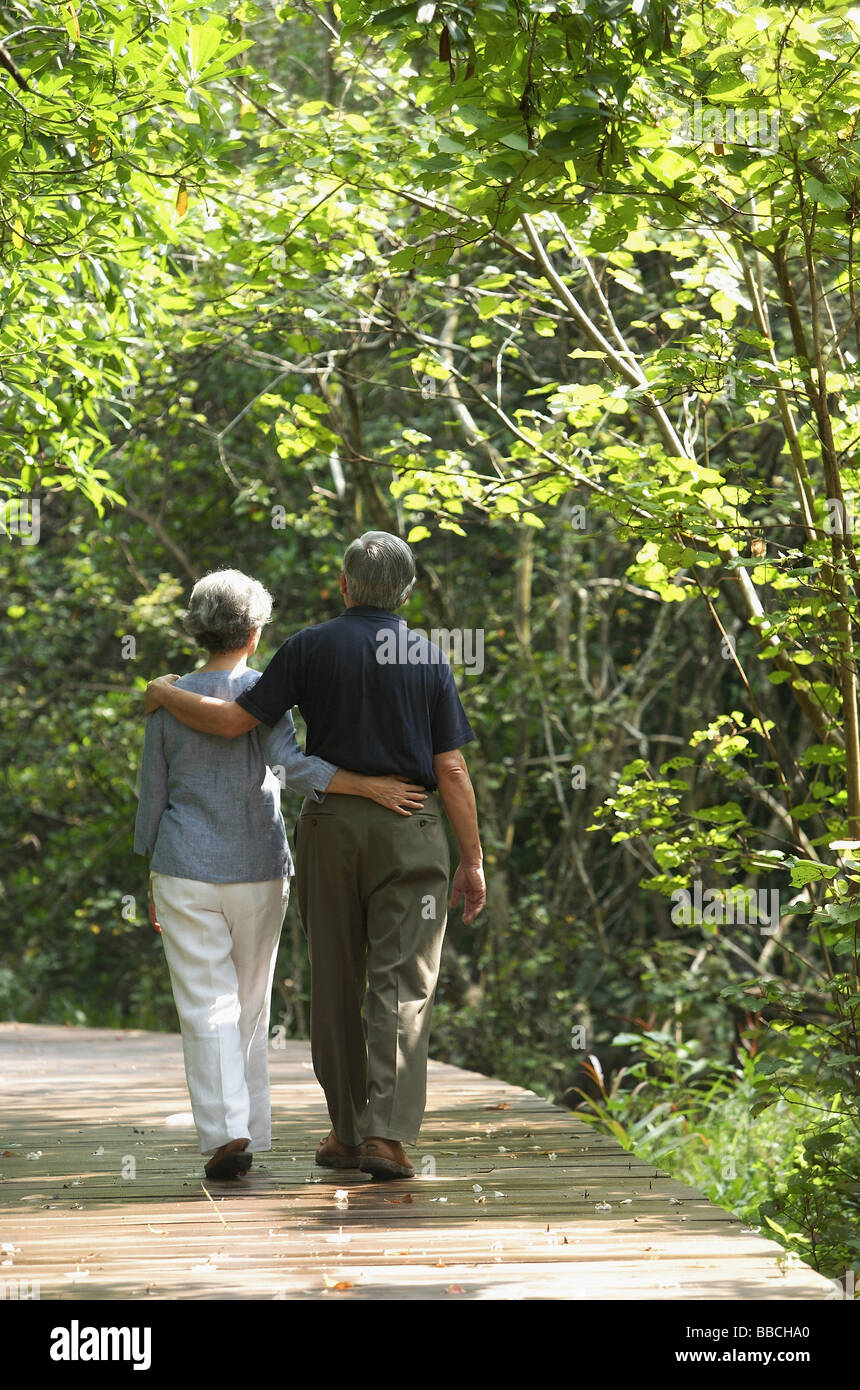Mature couple walking through park, rear view Stock Photo - Alamy