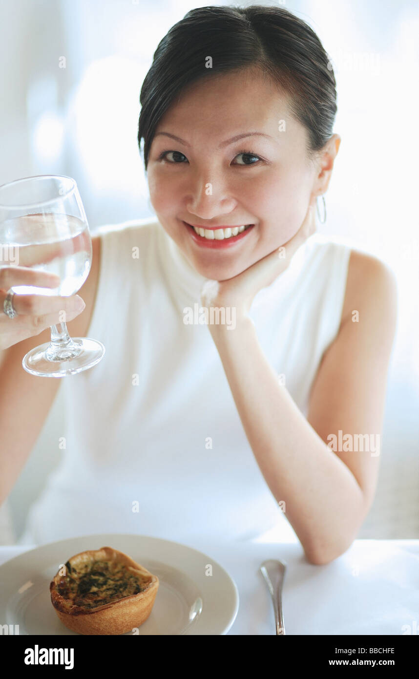Young woman holding glass of water, smiling at camera Stock Photo - Alamy