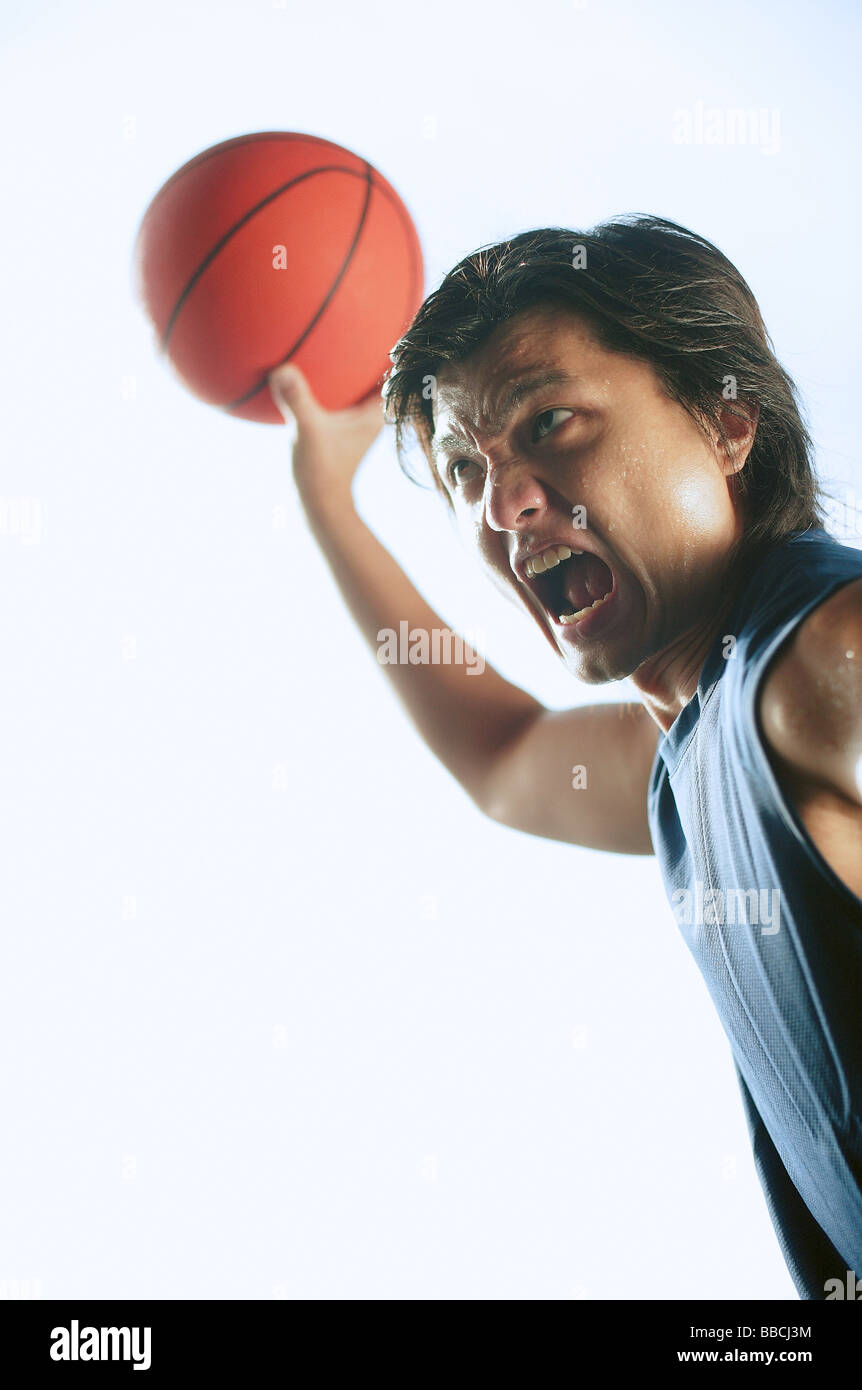 Man holding basketball in the air, mouth open Stock Photo Alamy