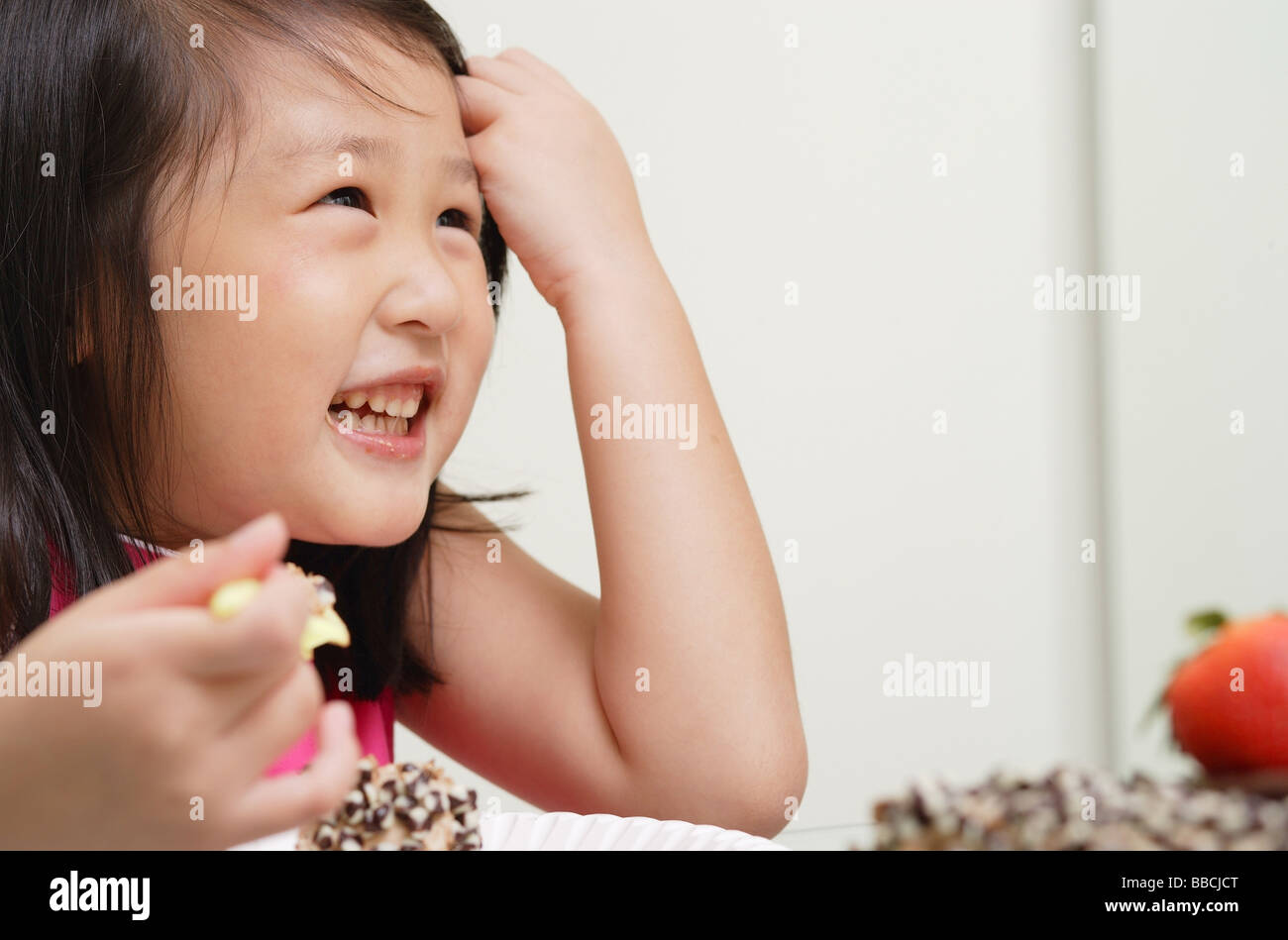Young girl pulling hair back from face, smiling Stock Photo - Alamy