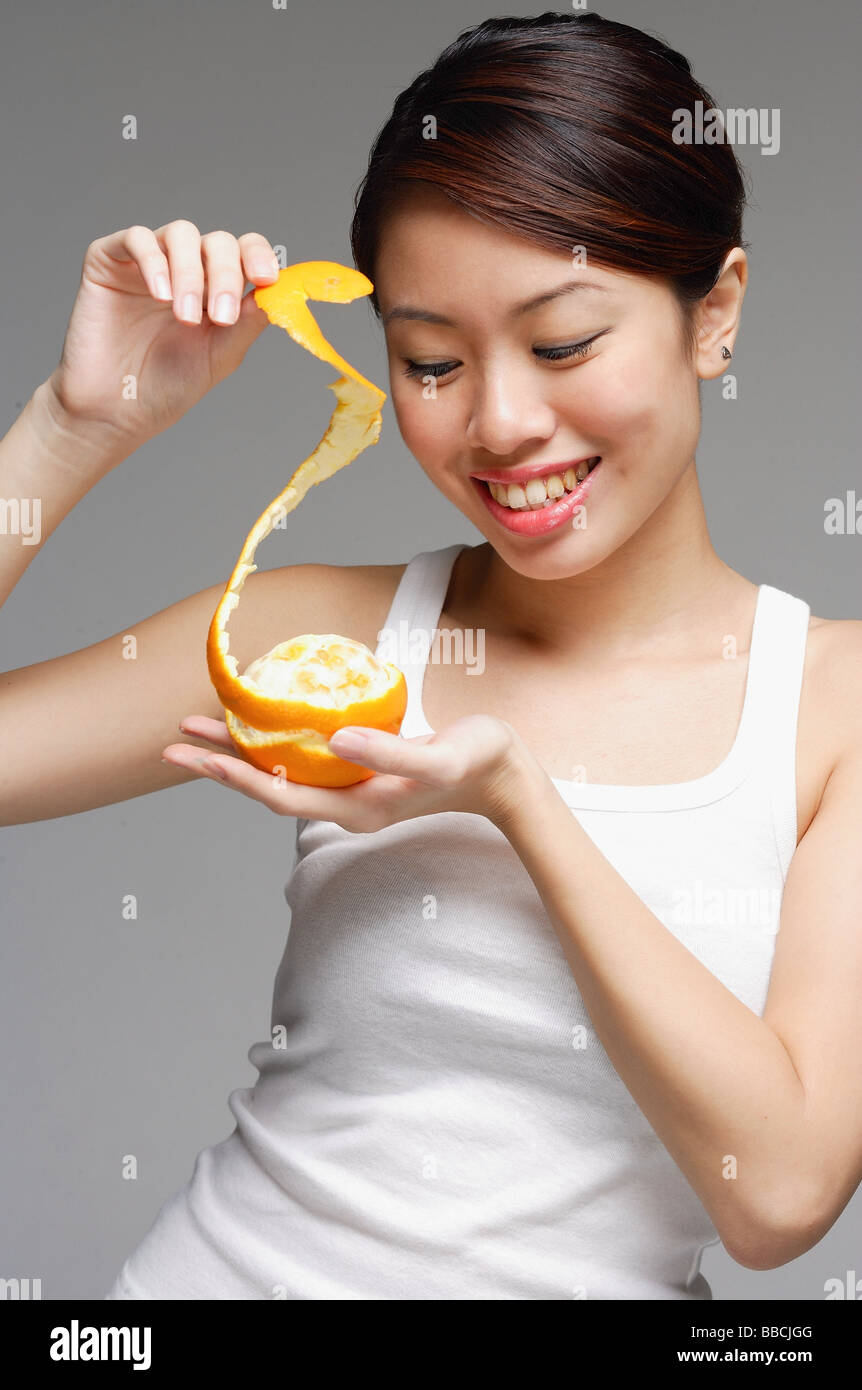 Woman Holding Orange And Pulling Orange Peel Stock Photo Alamy