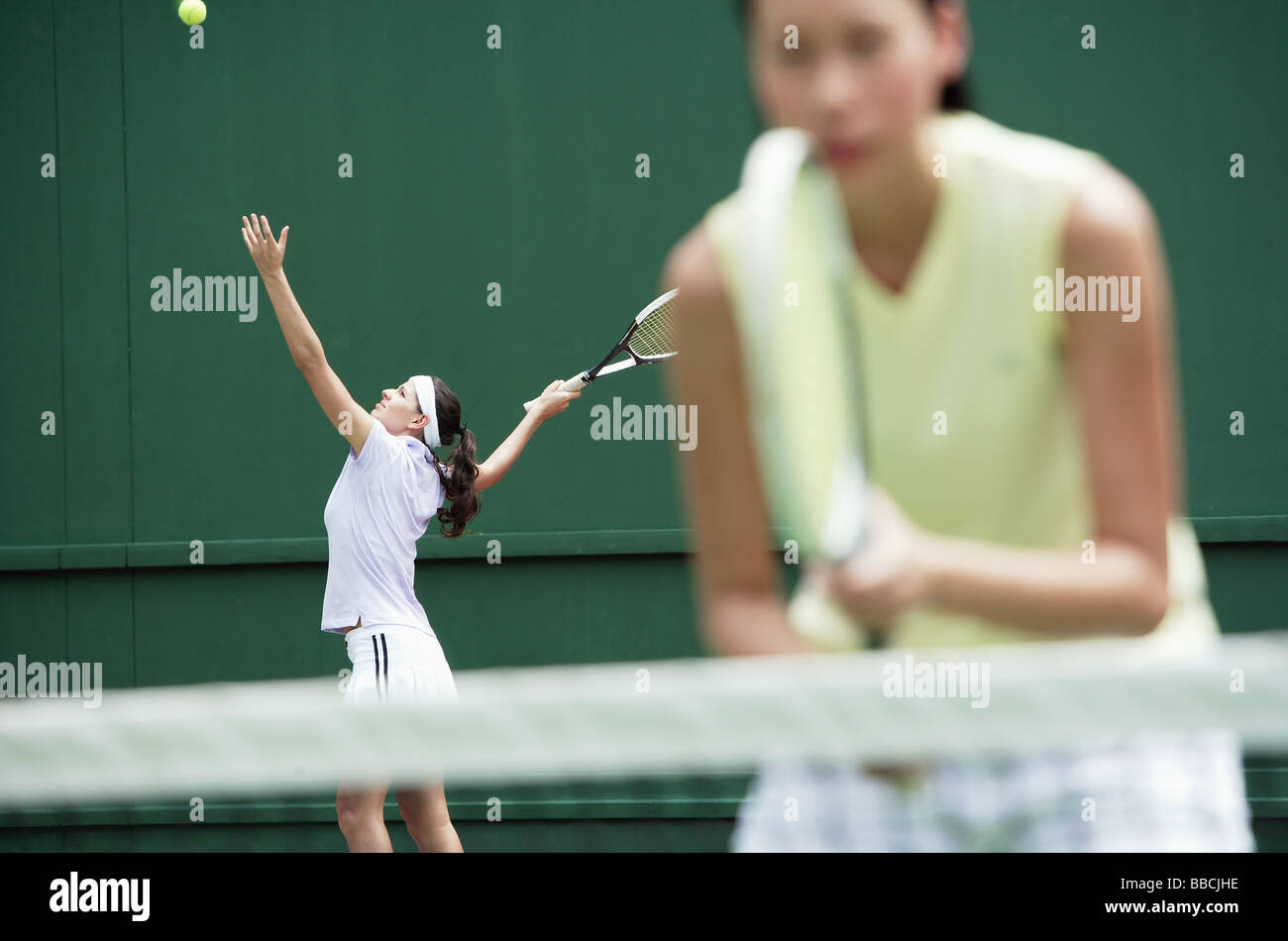 Women playing tennis together Stock Photo